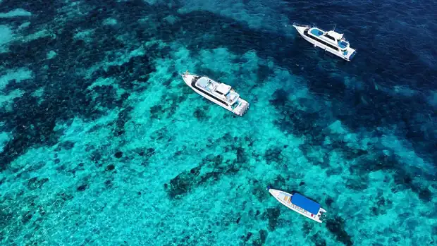 Boats moored in shallow blue water